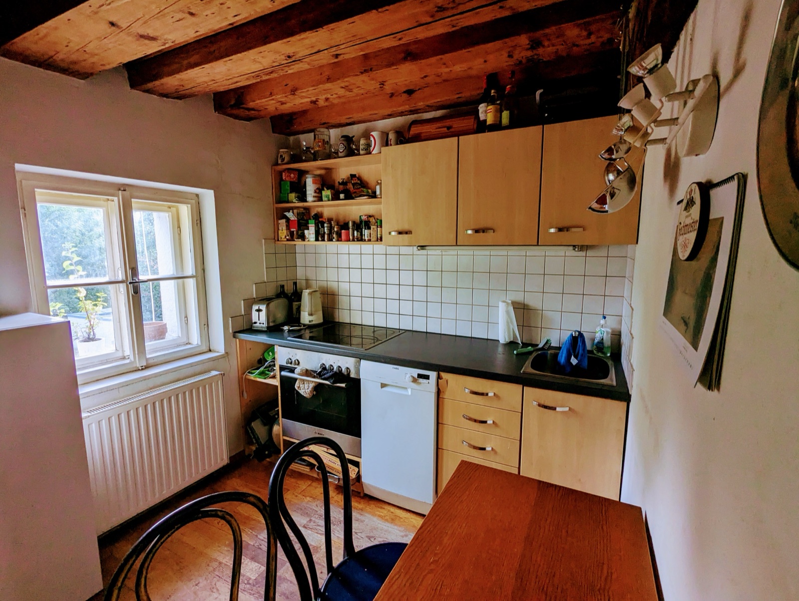 Essküche mit Herd, Backofen, Geschirrspüler, Esstisch und Fenster